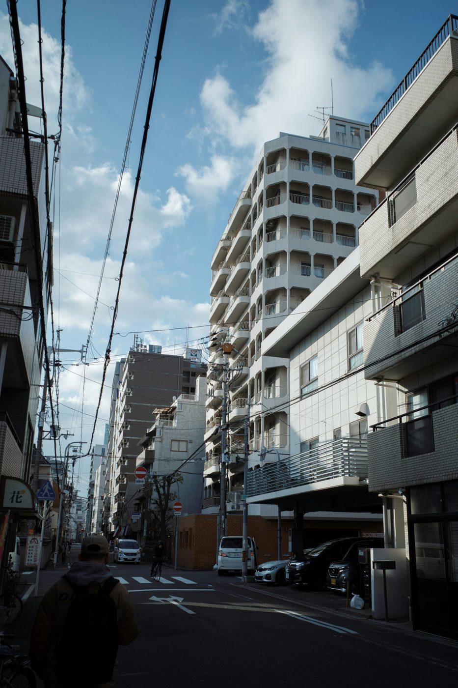 電線の走る通り沿いに建つマンション